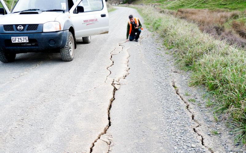 Staff assess earthquake damage to road. 