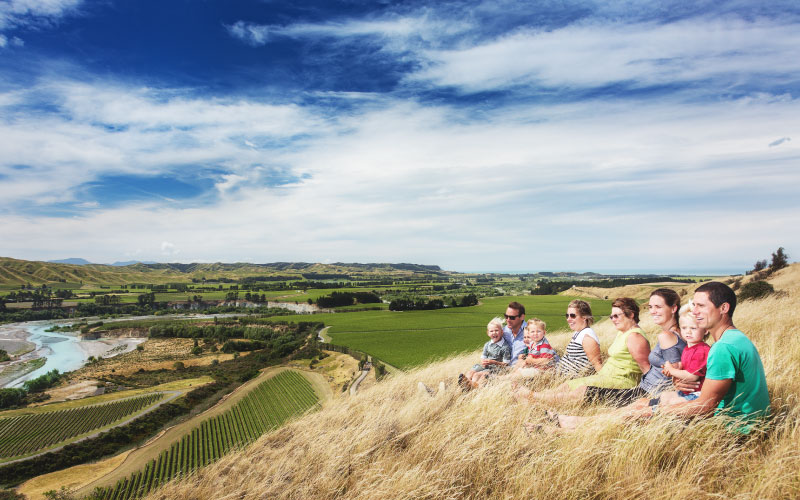 Family sitting on hillside in Seddon. 